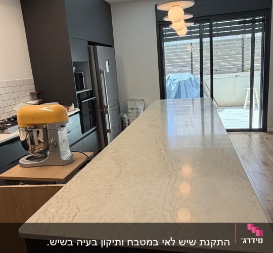 מטבח עם שיש בהיר ומכשירי חשמל